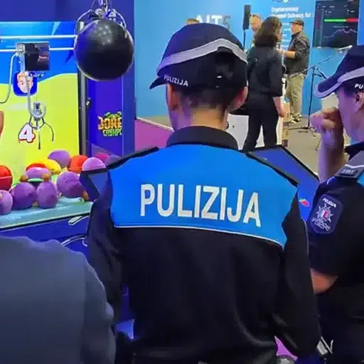 Maltese police officers playing the live Bonus Crab claw machine at the SiGMA Malta 2024 expo.